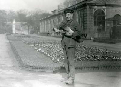 Keeper G. Blore carrying a grey crowned crane, London Zoo by Frederick William Bond